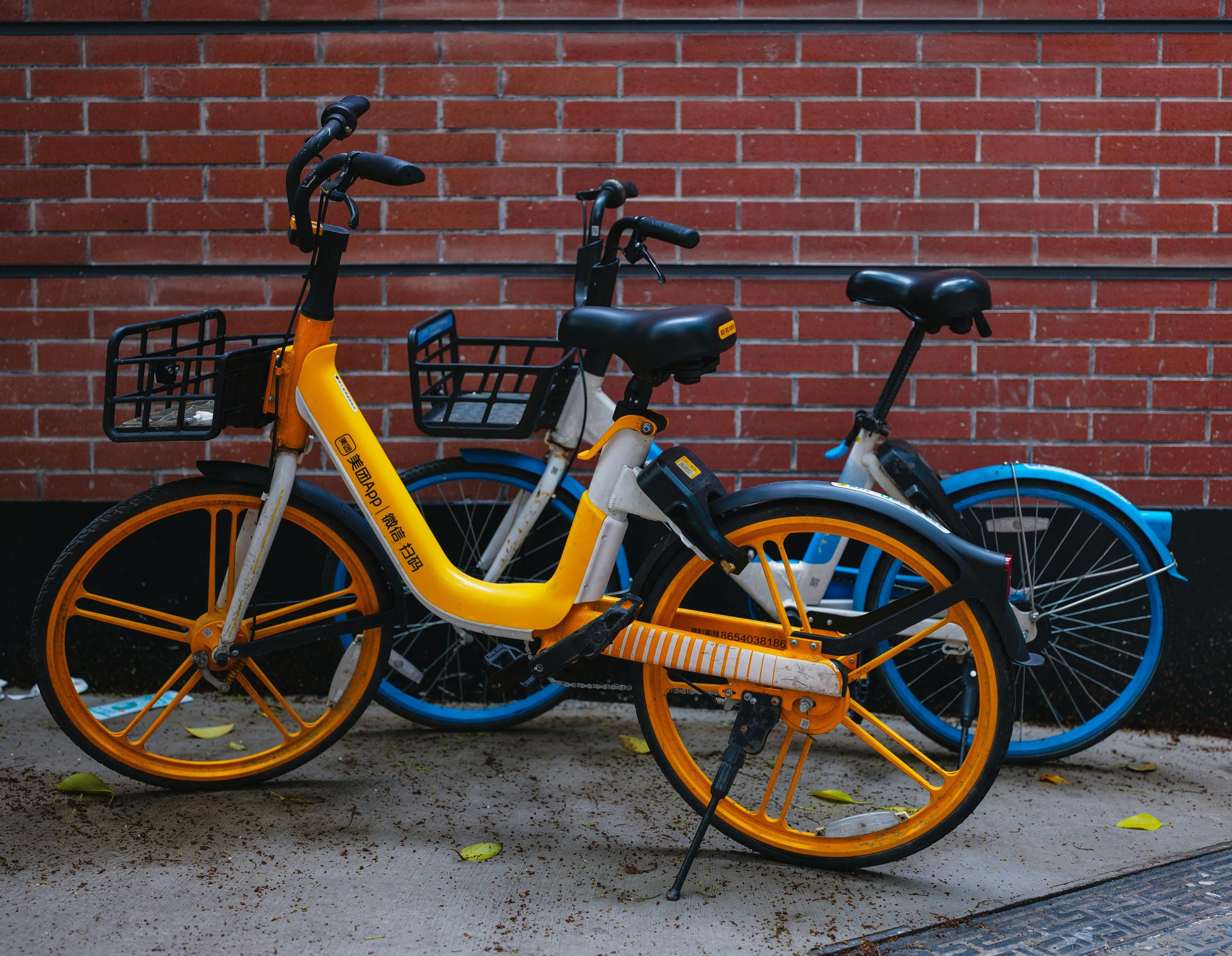 Scène urbaine de vélos vibrants garés contre un mur de briques rouges à Shanghai, en Chine.