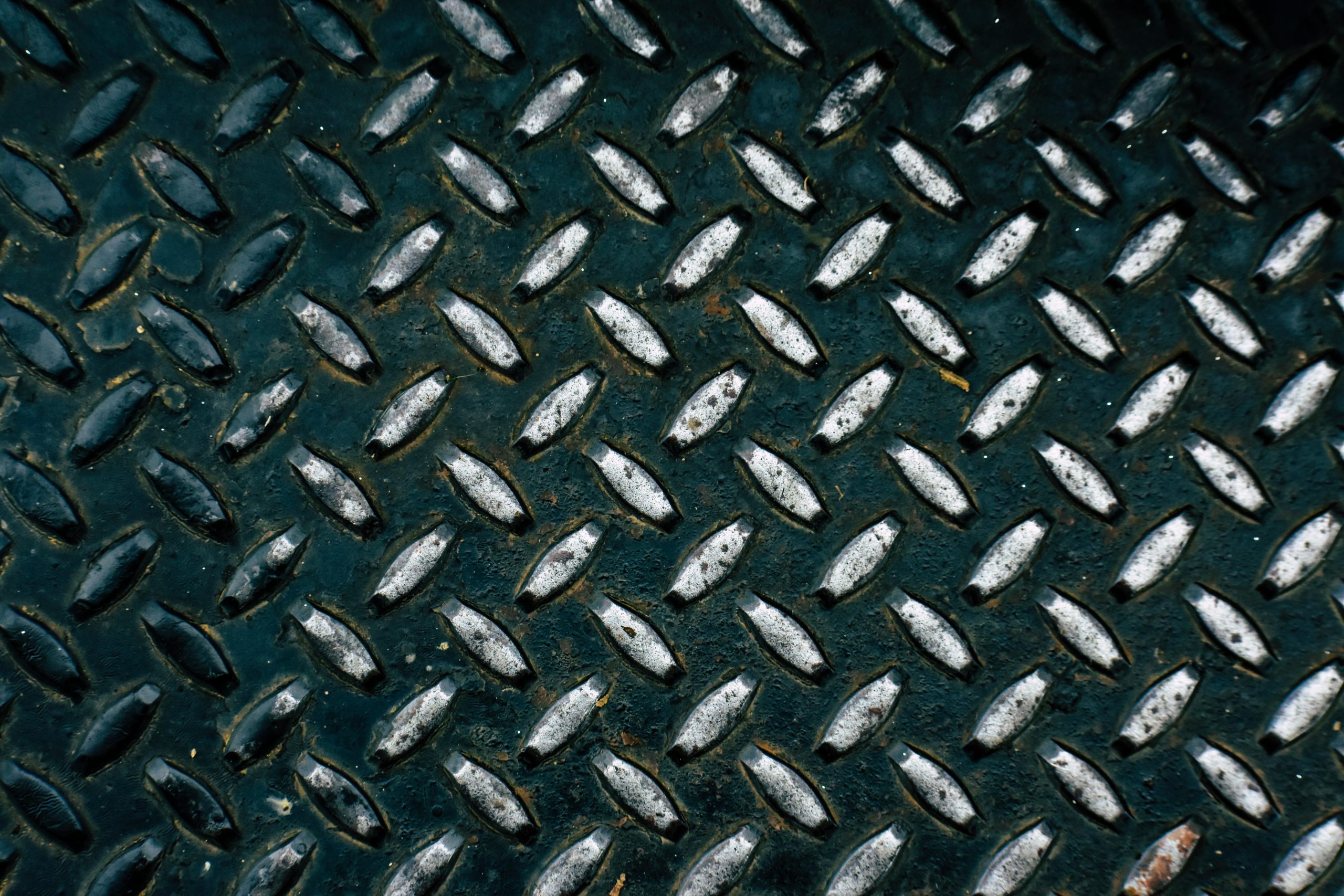 Détail d'une surface métallique en plaque de diamant montrant son motif rugueux.
