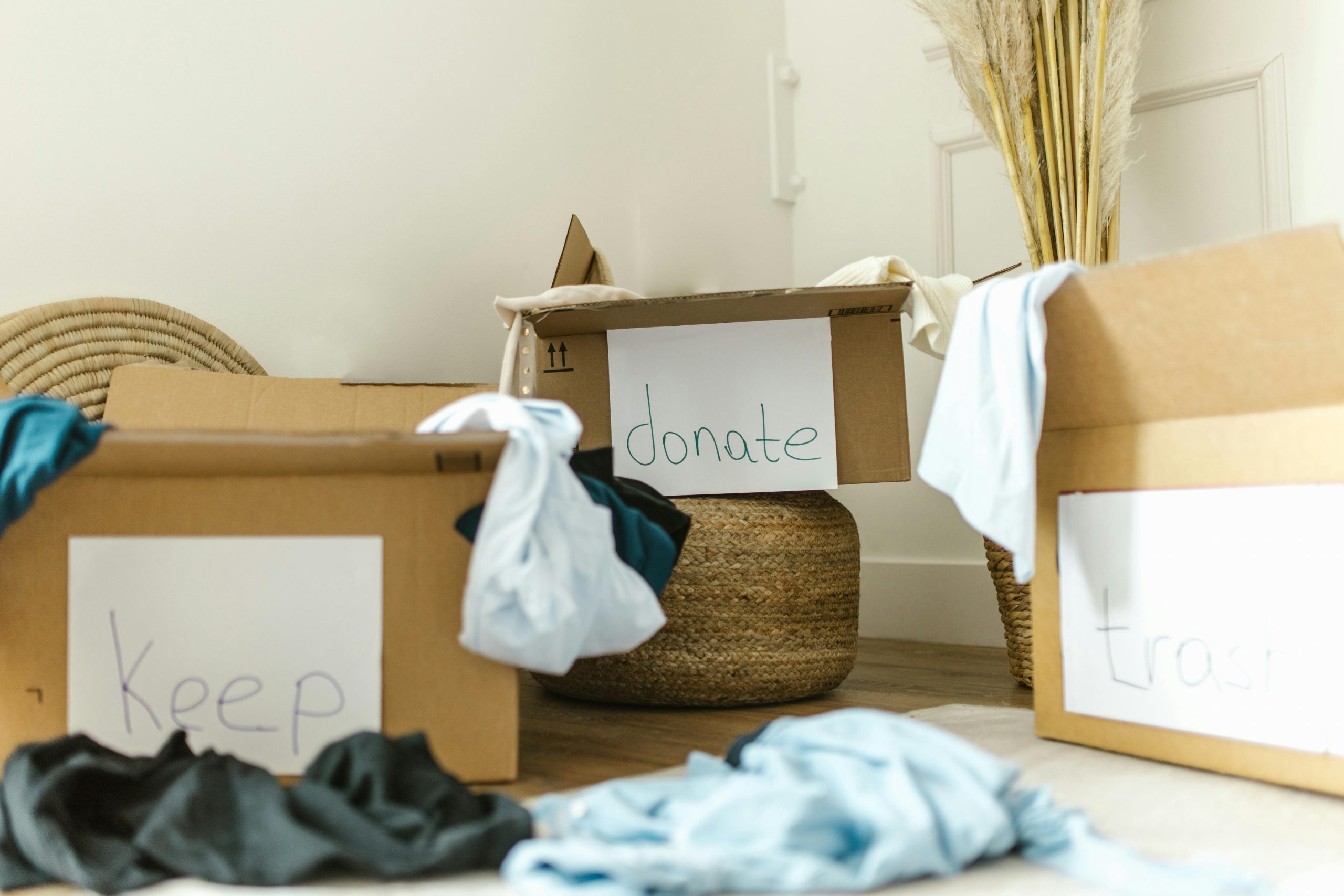Cardboard boxes étiquetées garder, donner et jeter pour une organisation efficace de la maison.