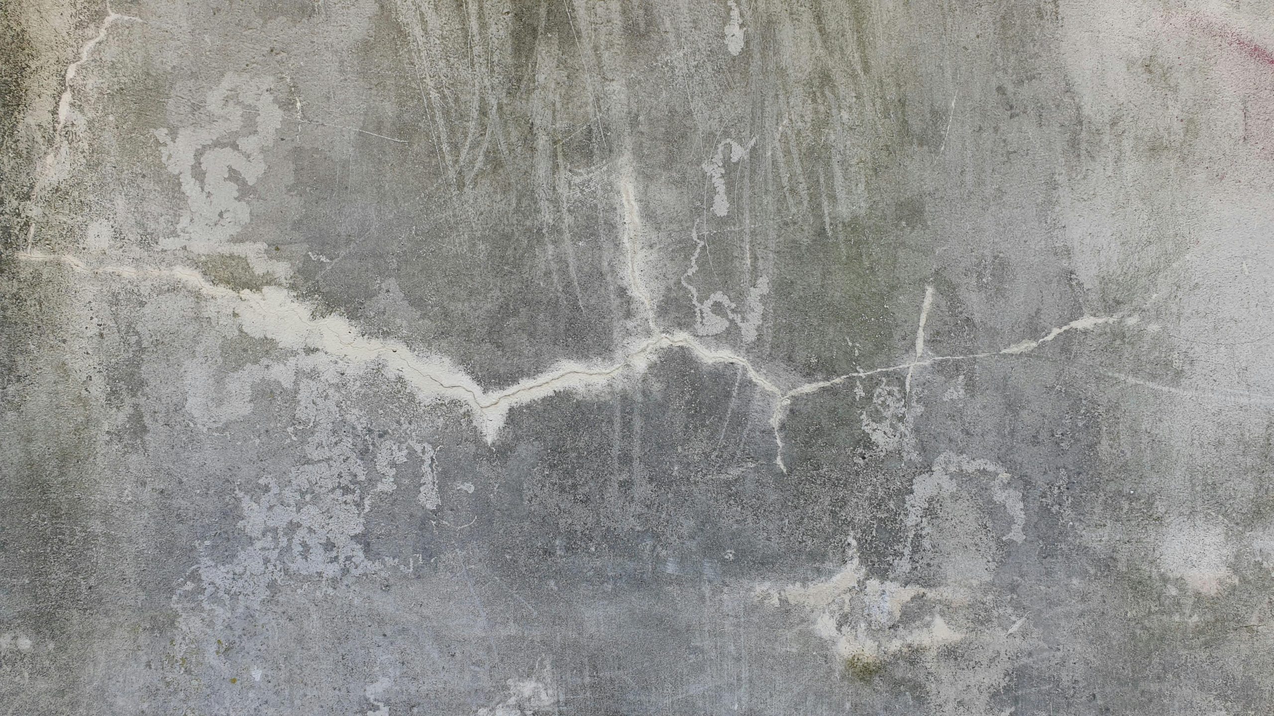 High-resolution image d'un mur en béton usé et fissuré, parfait pour une utilisation en fond texturé.