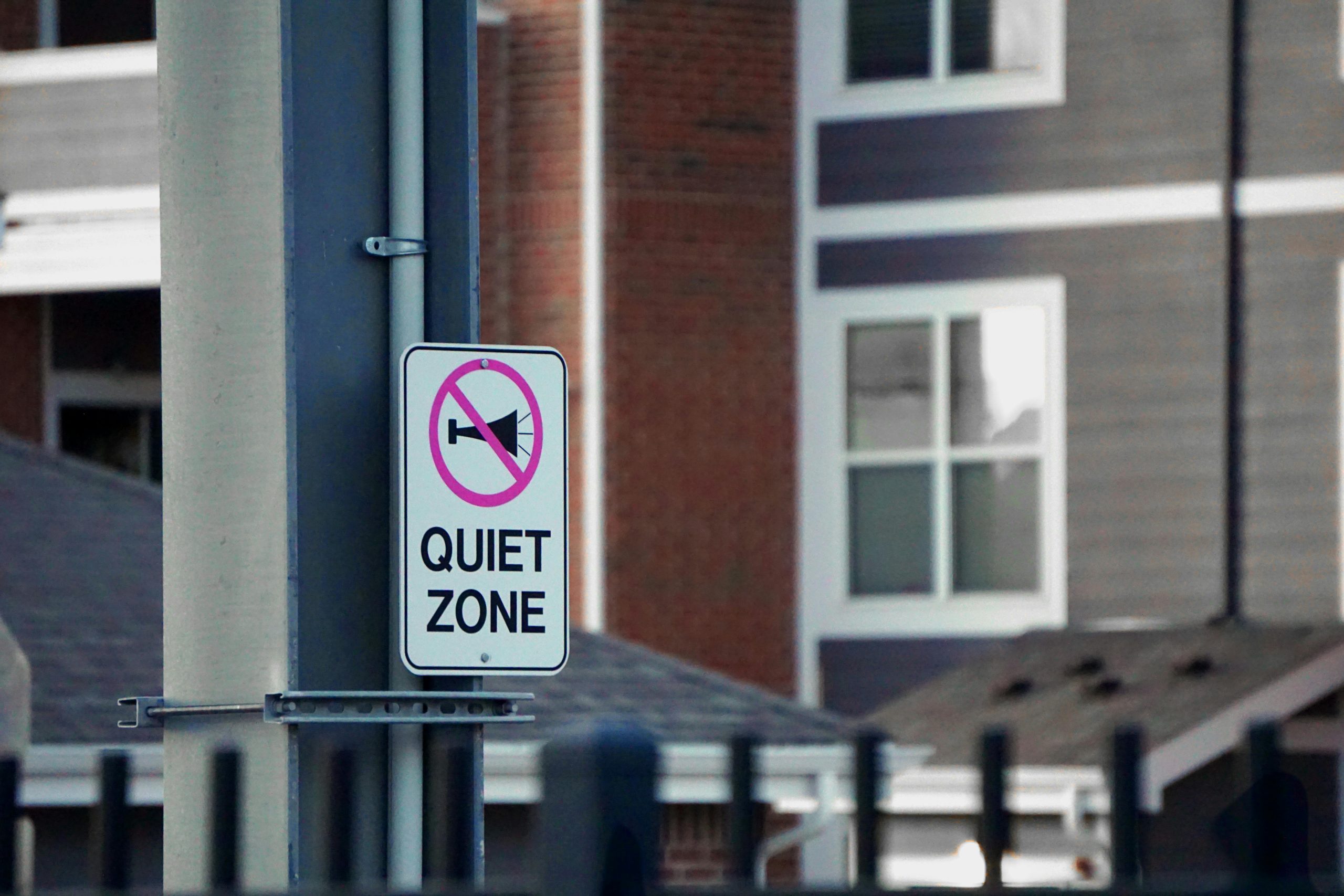 Panneau de zone silencieuse sur poteau devant des immeubles résidentiels urbains, véhiculant le silence et la paix.