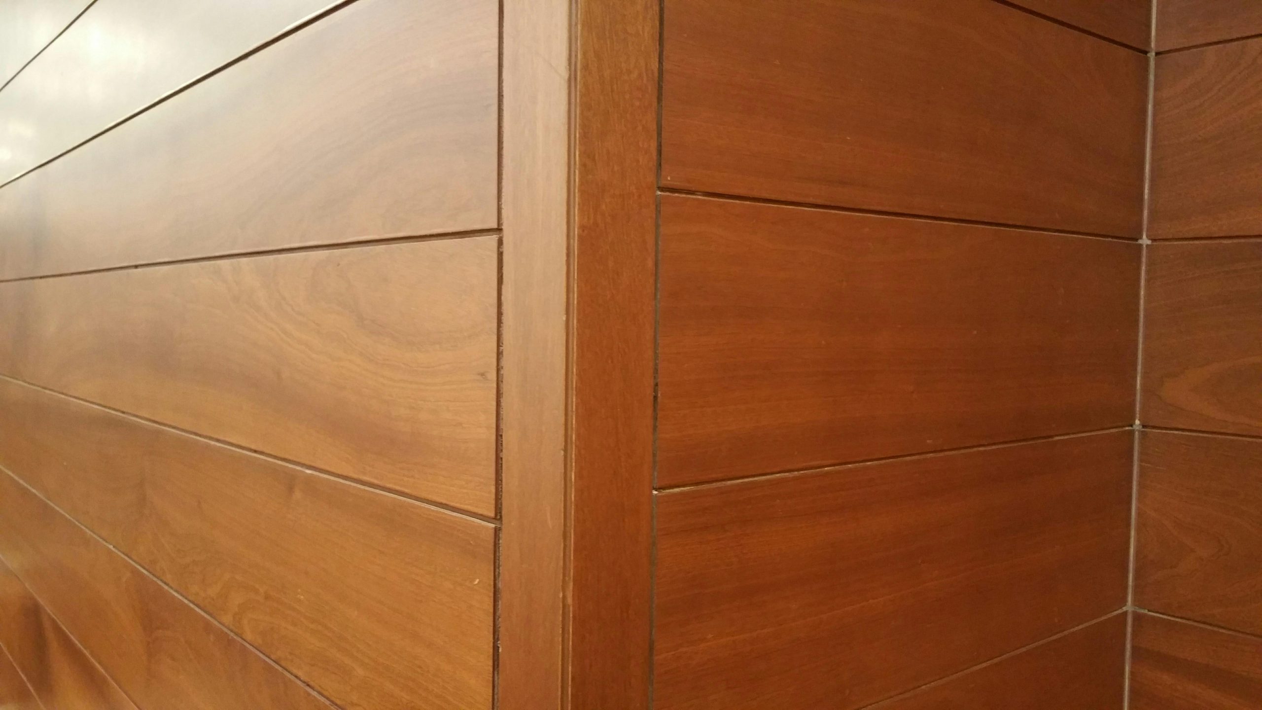 Close-up of modern wooden wall panels showcasing clean lines and texture. Gros plan sur des panneaux muraux en bois moderne mettant en évidence des lignes épurées et de la texture.