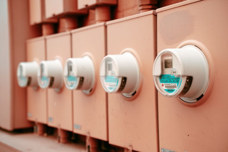 Close-up view of a row of industrial electricity meters for power monitoring and technology. Vue rapprochée d'une rangée de compteurs électriques industriels pour la surveillance de l'énergie et la technologie.