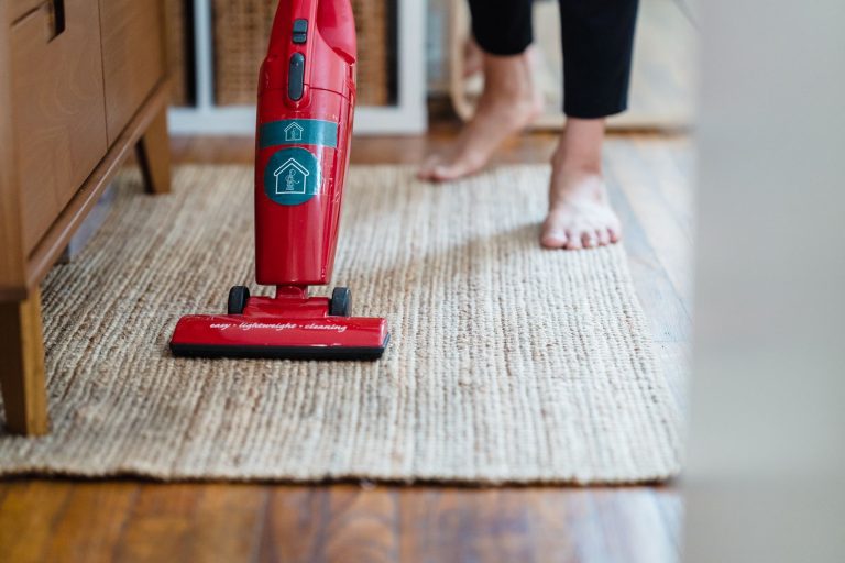 Aspirateur rouge utilise sur un tapis