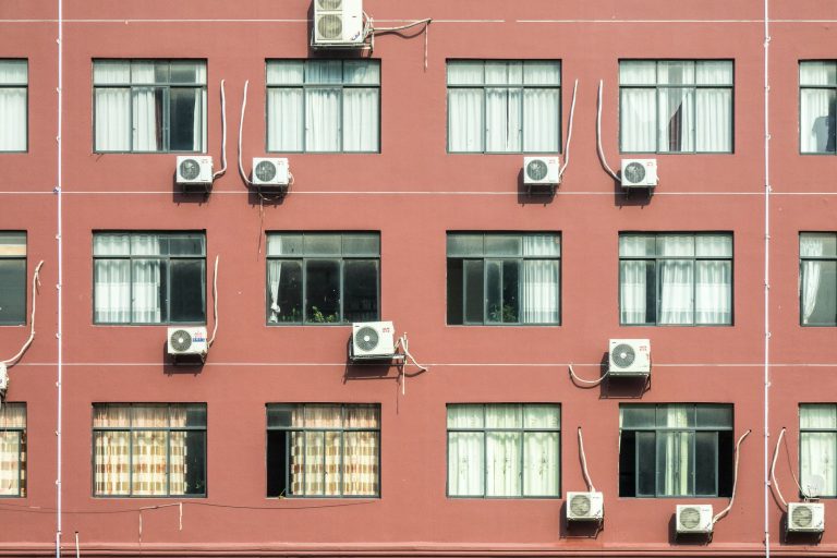 Façade d'immeuble avec plusieurs climatiseurs muraux