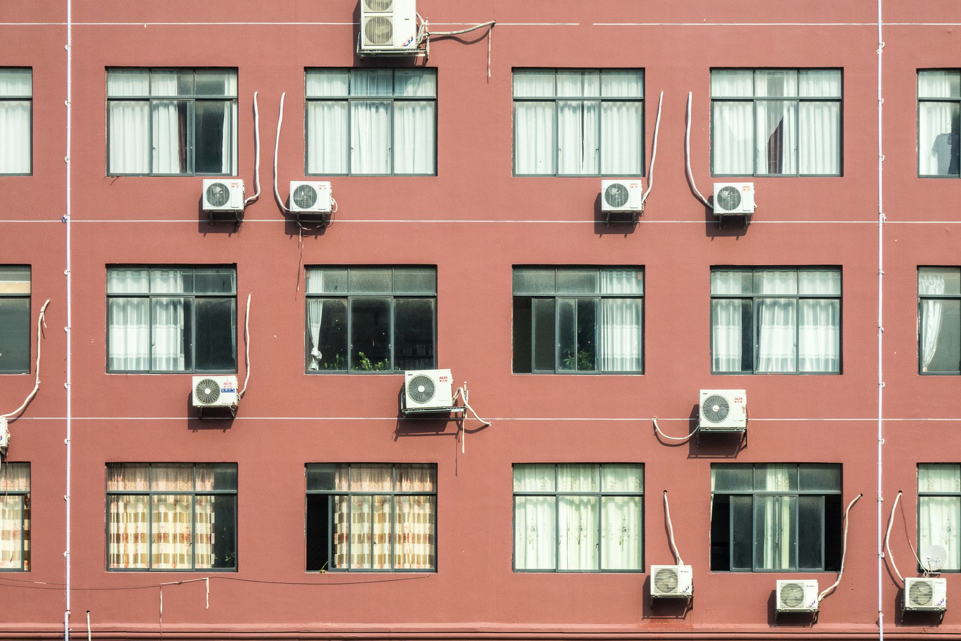 Façade d'immeuble avec plusieurs climatiseurs muraux