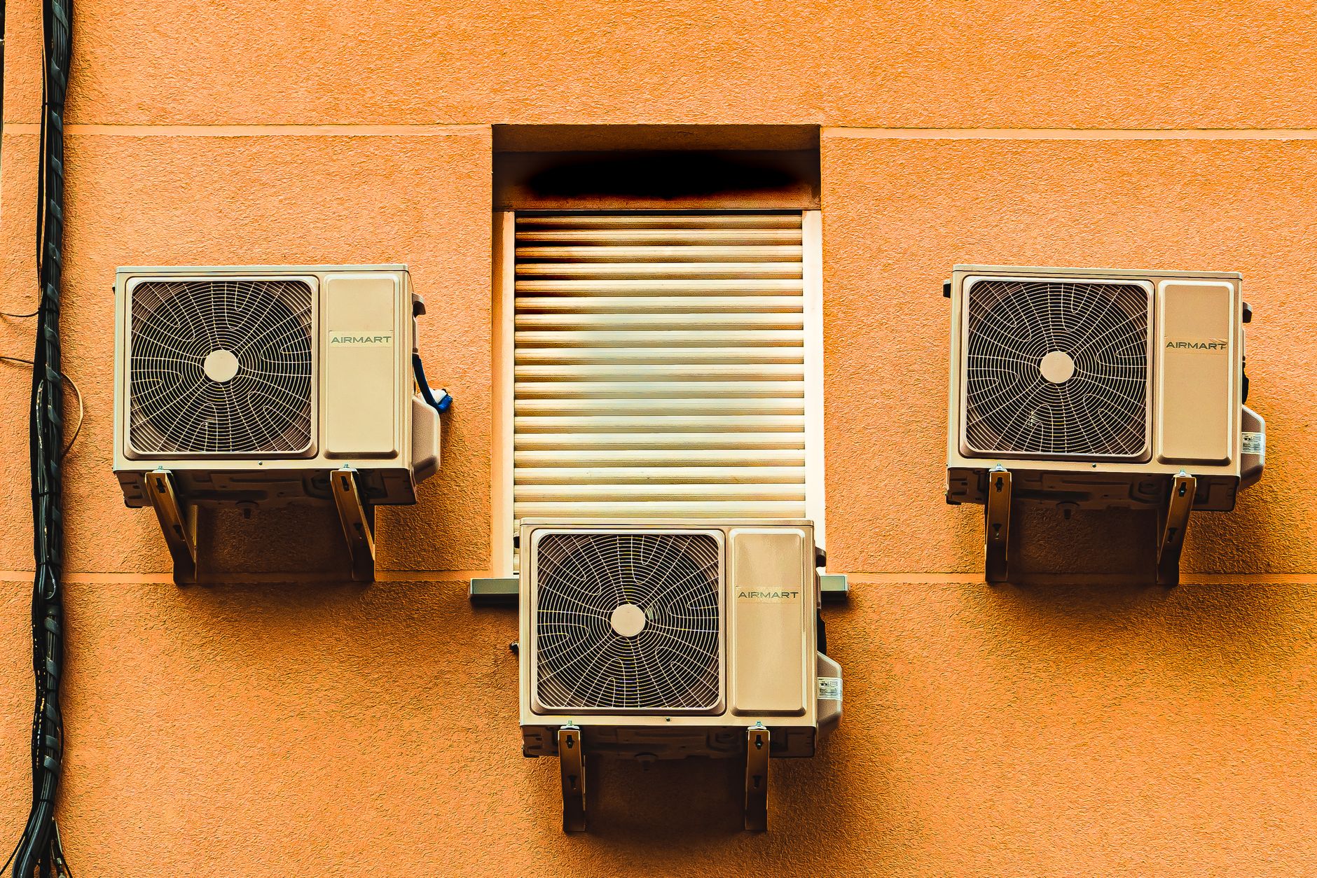 Trois climatiseurs fixés sur une façade extérieure