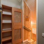 Warm and inviting wooden interior featuring rustic cabinet and shelved storage with a homey ambiance. Intérieur en bois chaleureux et accueillant avec armoire rustique et rangement sur étagères avec une ambiance chaleureuse.