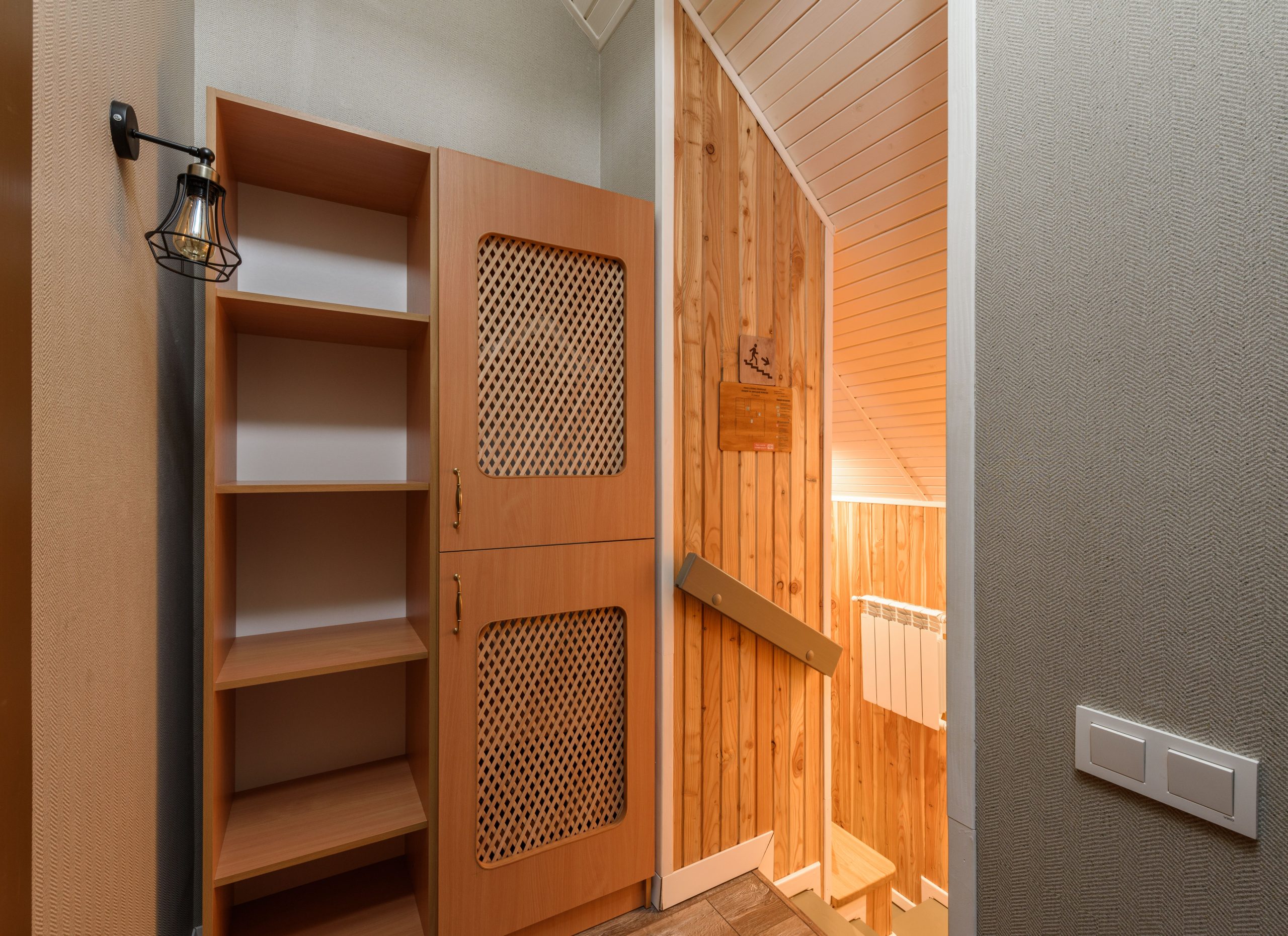 Warm and inviting wooden interior featuring rustic cabinet and shelved storage with a homey ambiance. Intérieur en bois chaleureux et accueillant avec armoire rustique et rangement sur étagères avec une ambiance chaleureuse.