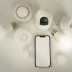 Détecteur de fumée et smartphone sur fond blanc
