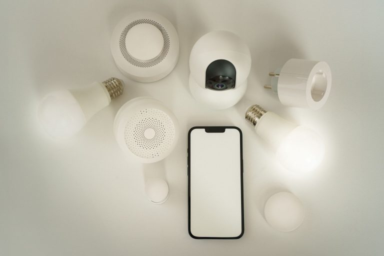 Détecteur de fumée et smartphone sur fond blanc