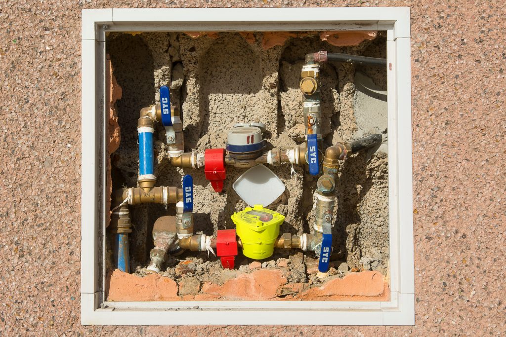 Compteur d'eau encastré dans un mur en béton