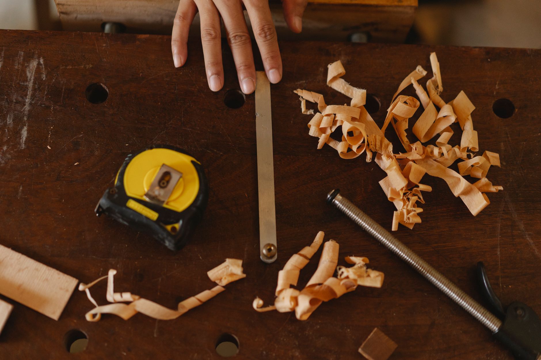 Artisan qui mesure une planche de bois