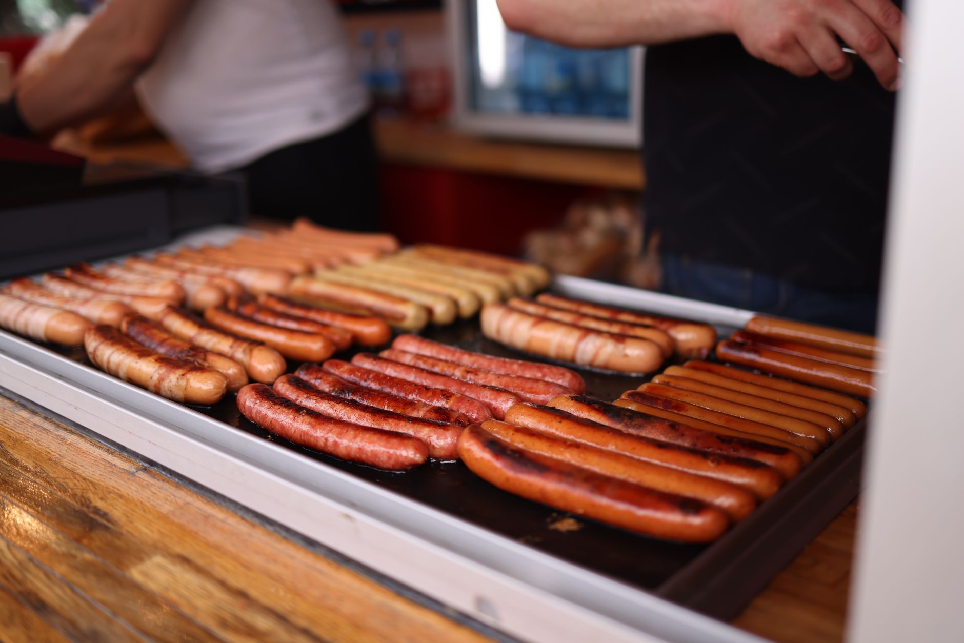 Saucisses qui cuisent sur une plaque en inox