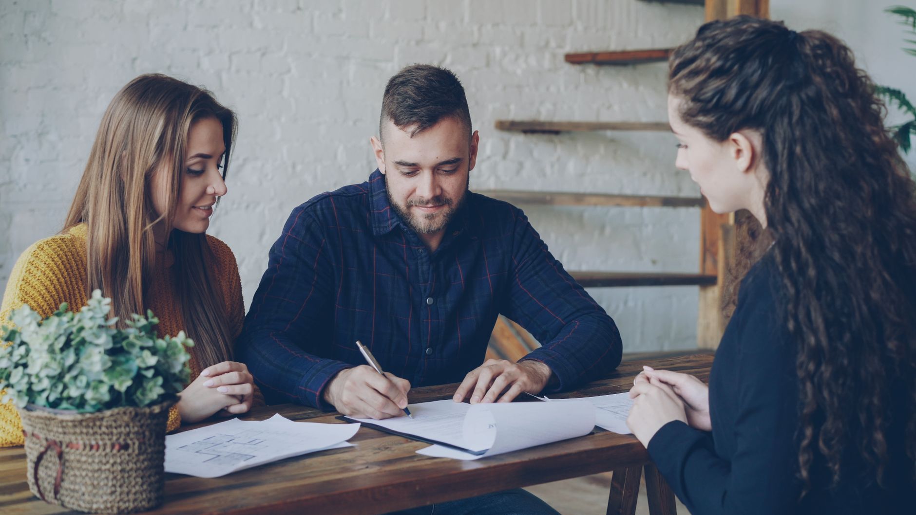 Couple signant des documents avec un professionnel de l'immobilier