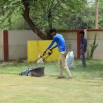 Jardiniers qui tondent une pelouse ensoleillee
