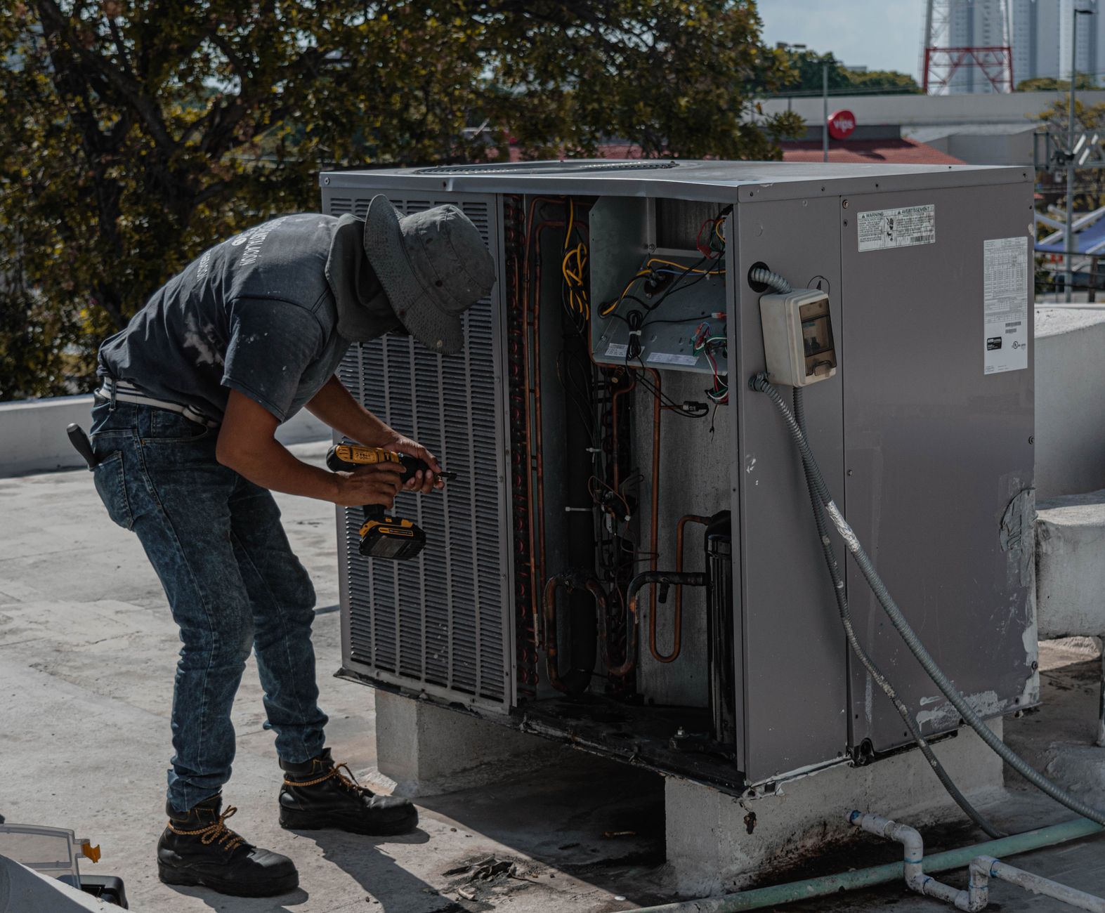 Technicien intervenant sur un climatiseur en toiture