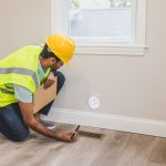 Ouvrier inspectant une bouche d'aeration avant travaux de renovation