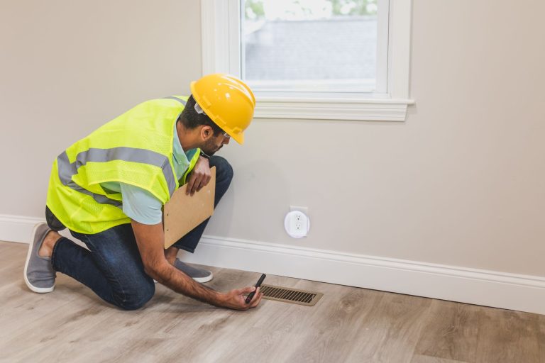Ouvrier inspectant une bouche d'aeration avant travaux de renovation
