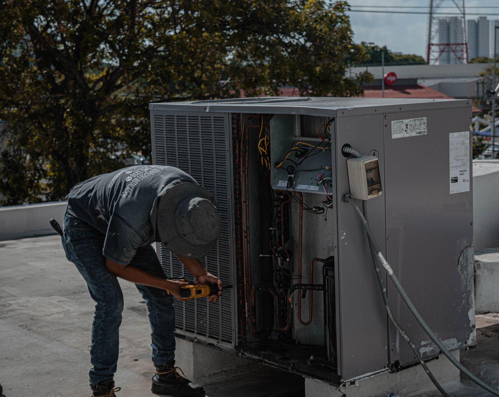Technicien réparant une unité de climatisation en extérieur